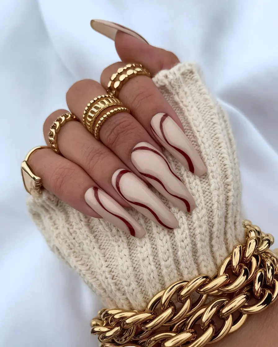 long fall nails trends 2025 Abstract Cream Swirls with Red Contour