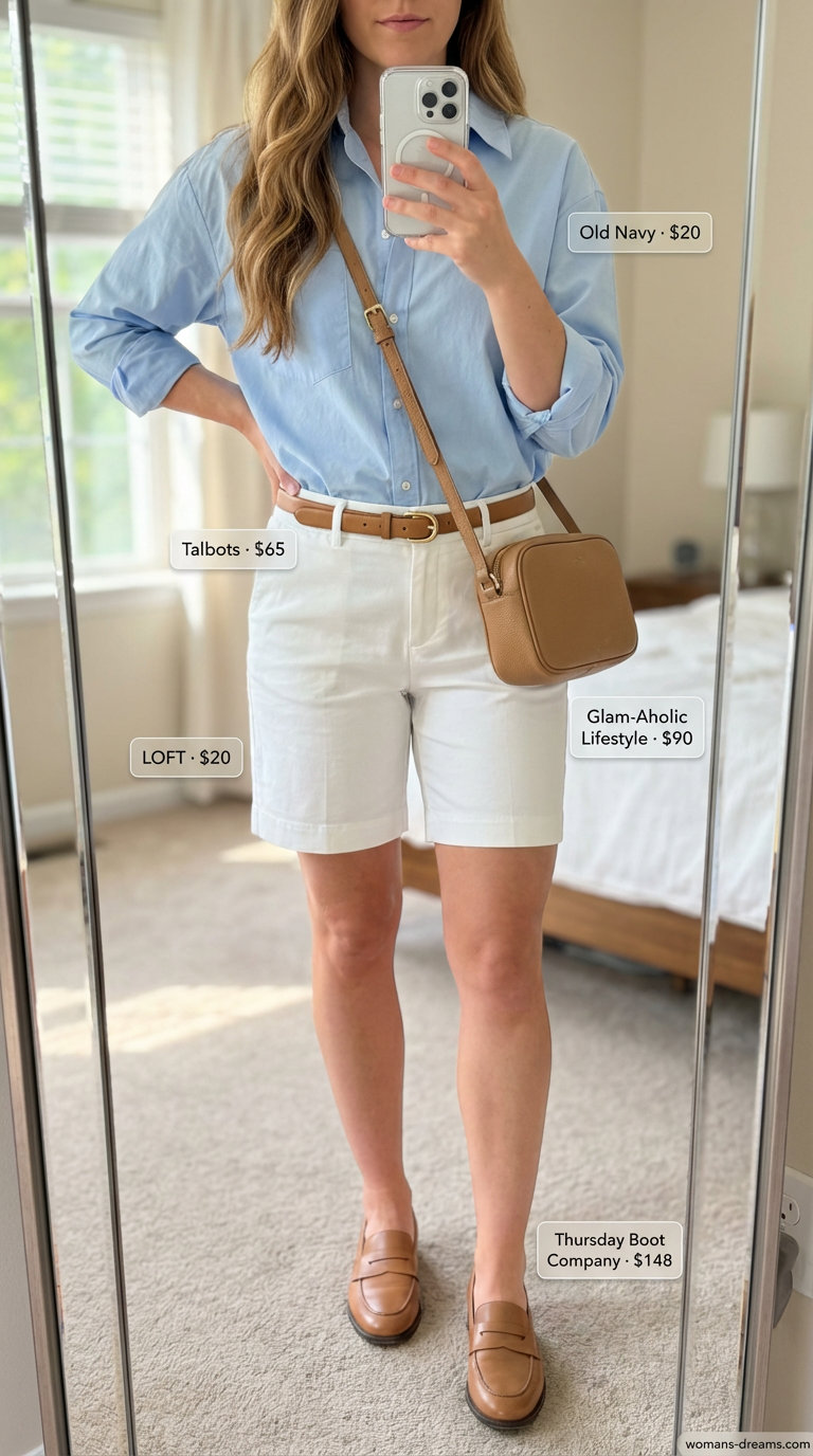 Polished summer fashion outfits for women 2026 featuring white Bermuda shorts, a light blue oversized button-down, tan loafers, a tan belt, and a navy crossbody bag perfect for casual office or lunch.