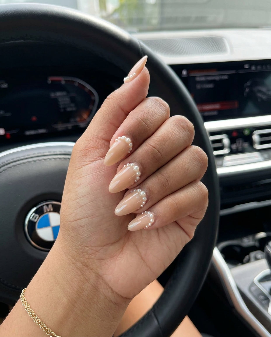 Sophisticated nude beige shell summer nails 2026 with delicate cream pearl accents for office or bridal.