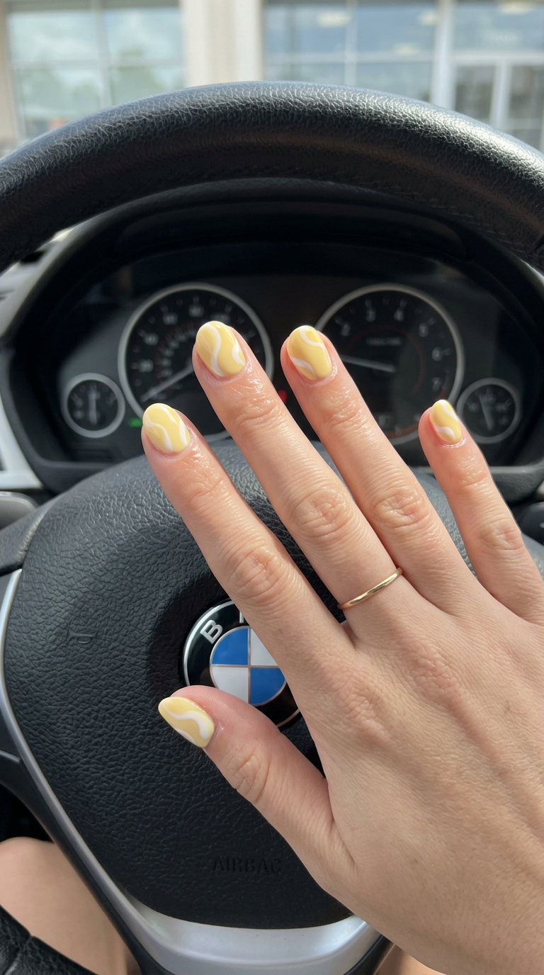 Butter Yellow Swirl Nails 2026 Short round summer nails 2026: Artistic butter yellow creamy swirls for casual chic or gallery visits.