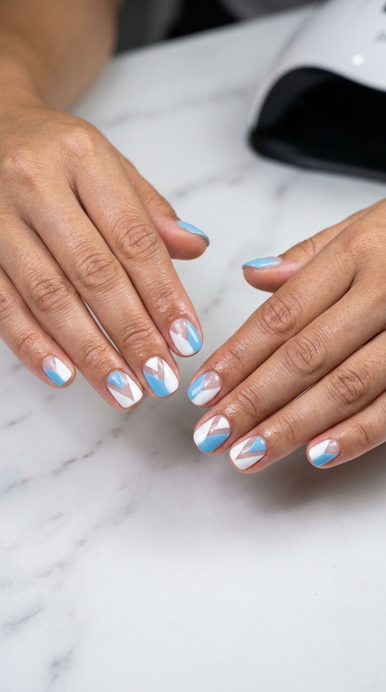 Sky Blue Geometric Nails 2026: Date Night Style Sky blue geometric block short round summer nails 2026. Edgy, modern, polished look with white and clear negative space.