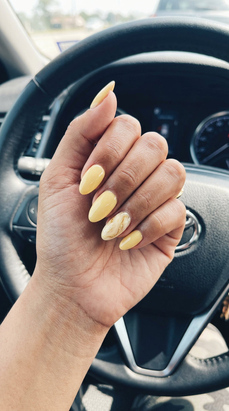 Marble Butter Yellow Oval Nails 2026 Marble butter accent oval nails with ivory and gold veins for date night, a sophisticated summer nails yellow 2026 option.