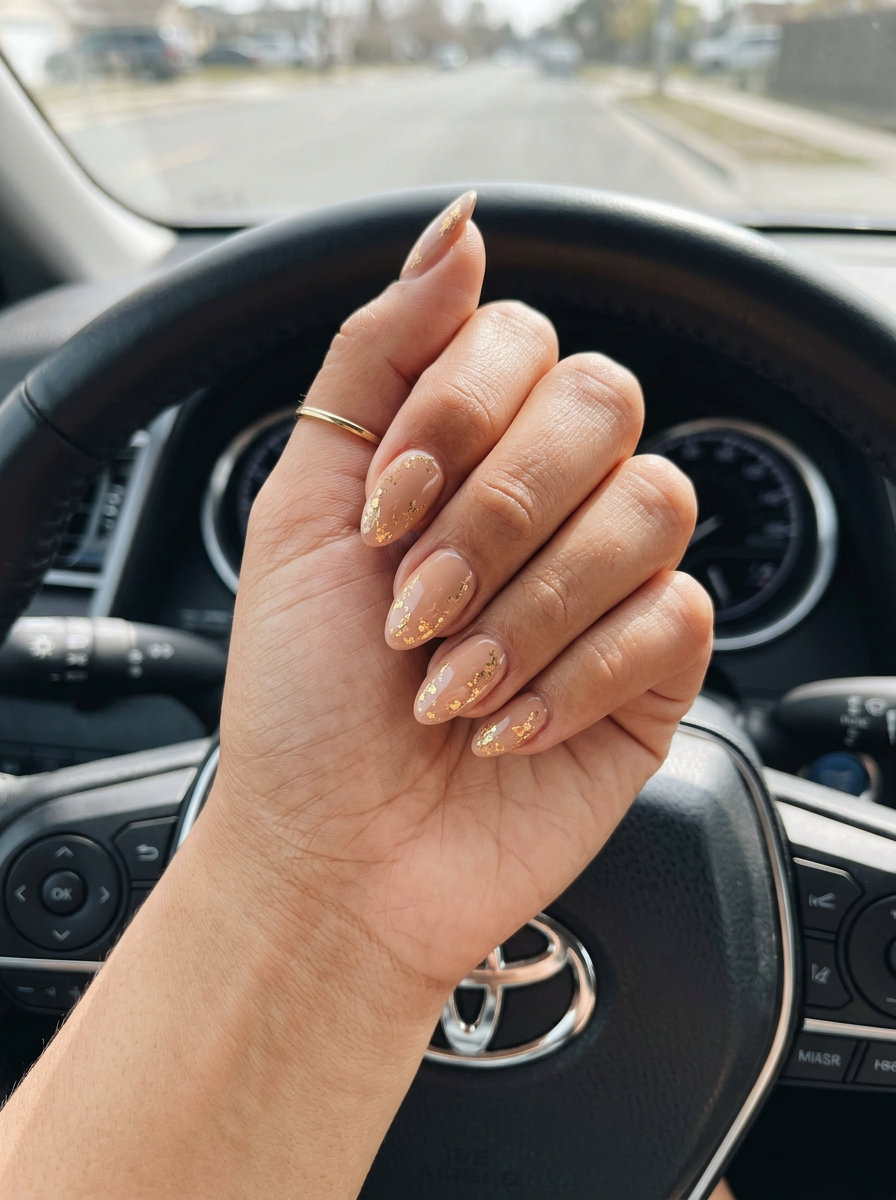 Summer Vibes Nails 2026: Golden Hour Almond Luxury Summer vibes nails 2026: Golden hour warm nude with metallic gold flakes on almond nails.