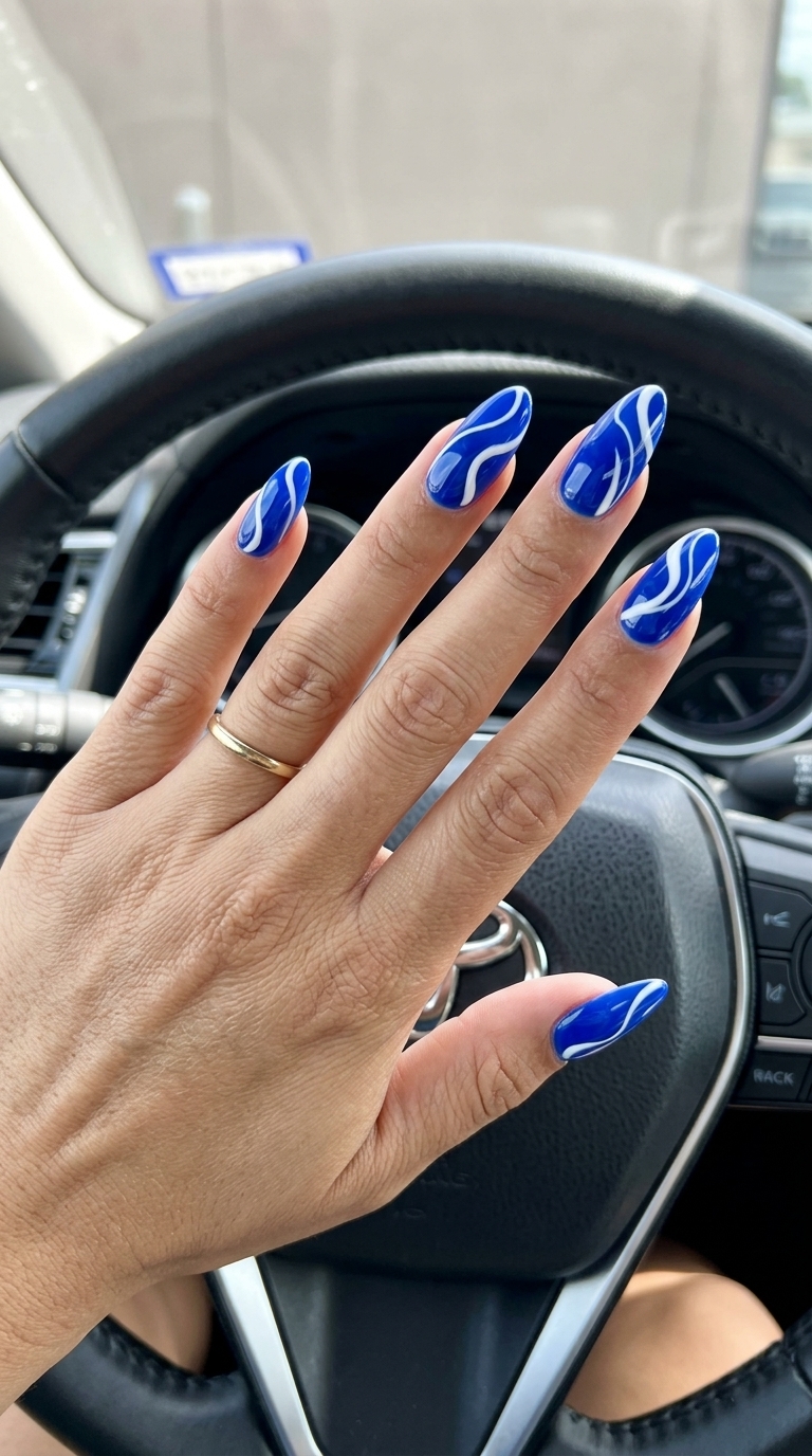 Cobalt Blue Abstract Swirls nails for summer 2026: blue base with white artistic swirls. Chic art gallery visit style.