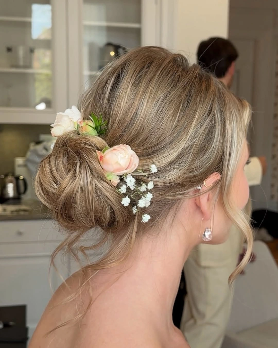 bridesmaid hairstyling Romantic Low Bun With Fresh Floral Accents