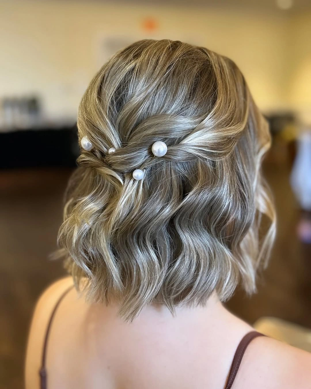 bridesmaid hairstyling Soft Pearl Waves for an Elegant Half-Up Style