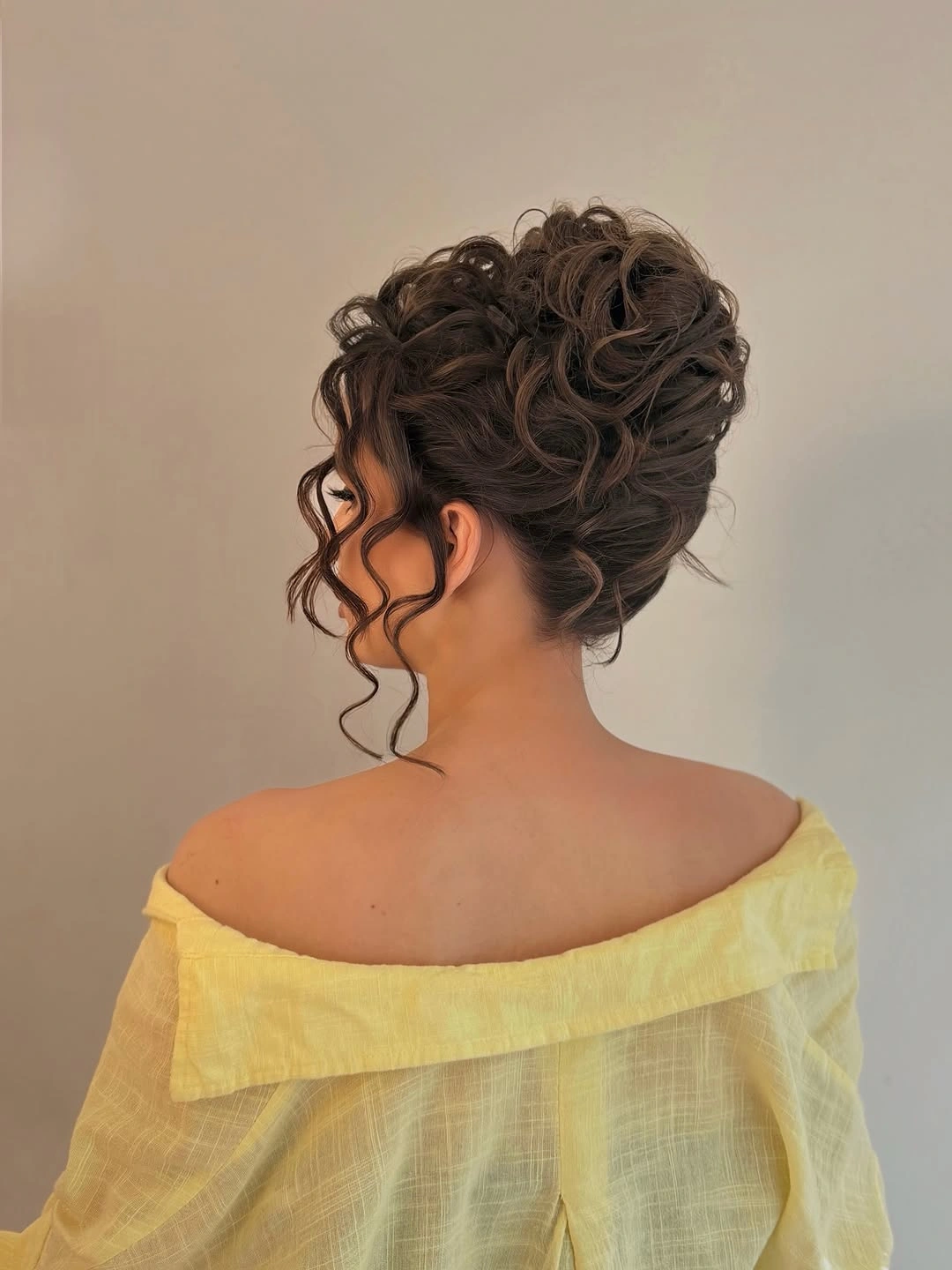 Fall hairstyles for wedding guests 2026 Voluminous Curly Updo for an Elegant Evening Celebration