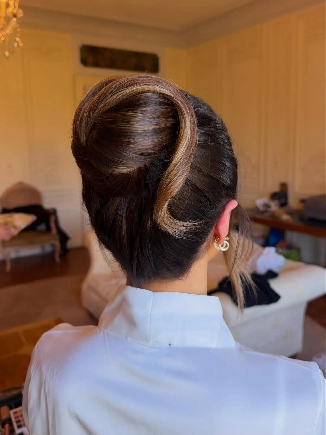 Fall hairstyles for wedding guests 2026 Modern Sleek Bun with a Sculptural Twist