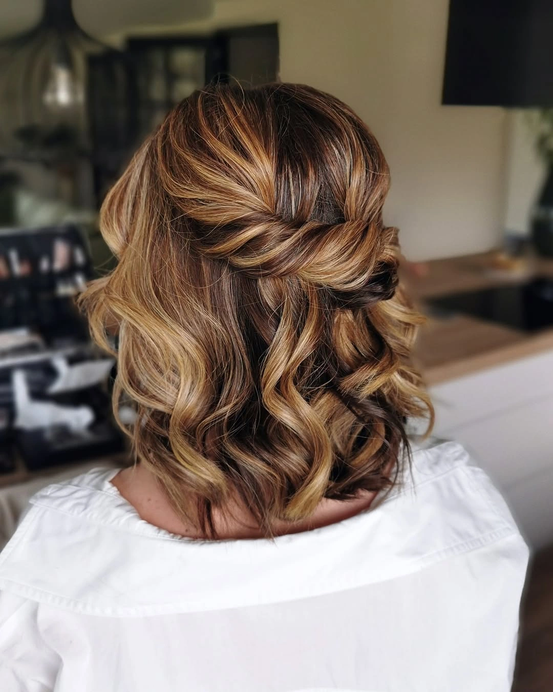 Fall hairstyles for wedding guests 2026 Low Twisted Bun with Delicate Pearl Accent