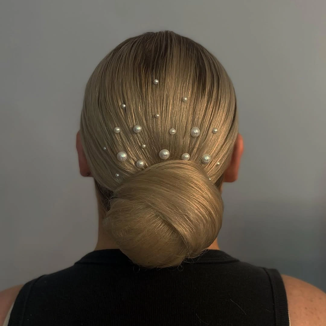 Fall hairstyles for wedding guests 2026 Minimalist Sleek Bun with Delicate Pearl Details
