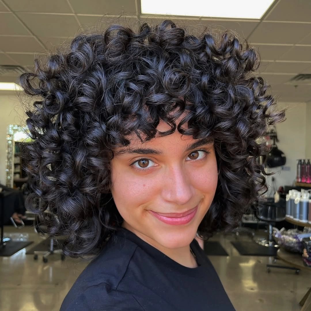 September hairstyles ideas 2026 Short Black Curls With Full Fringe