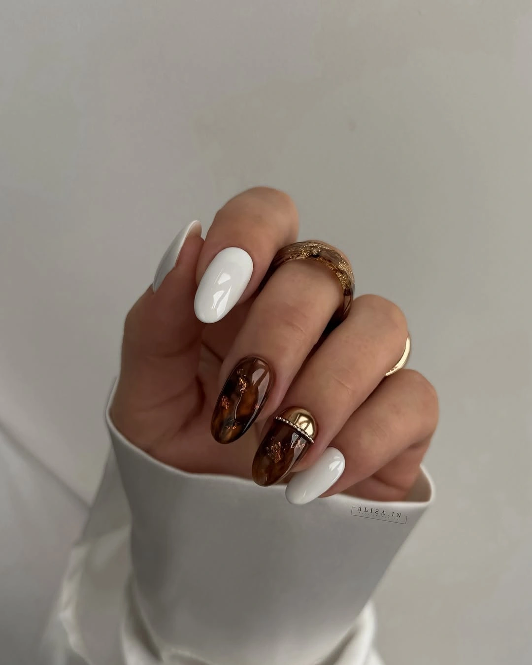 medium almond milky nails with warm brown accents