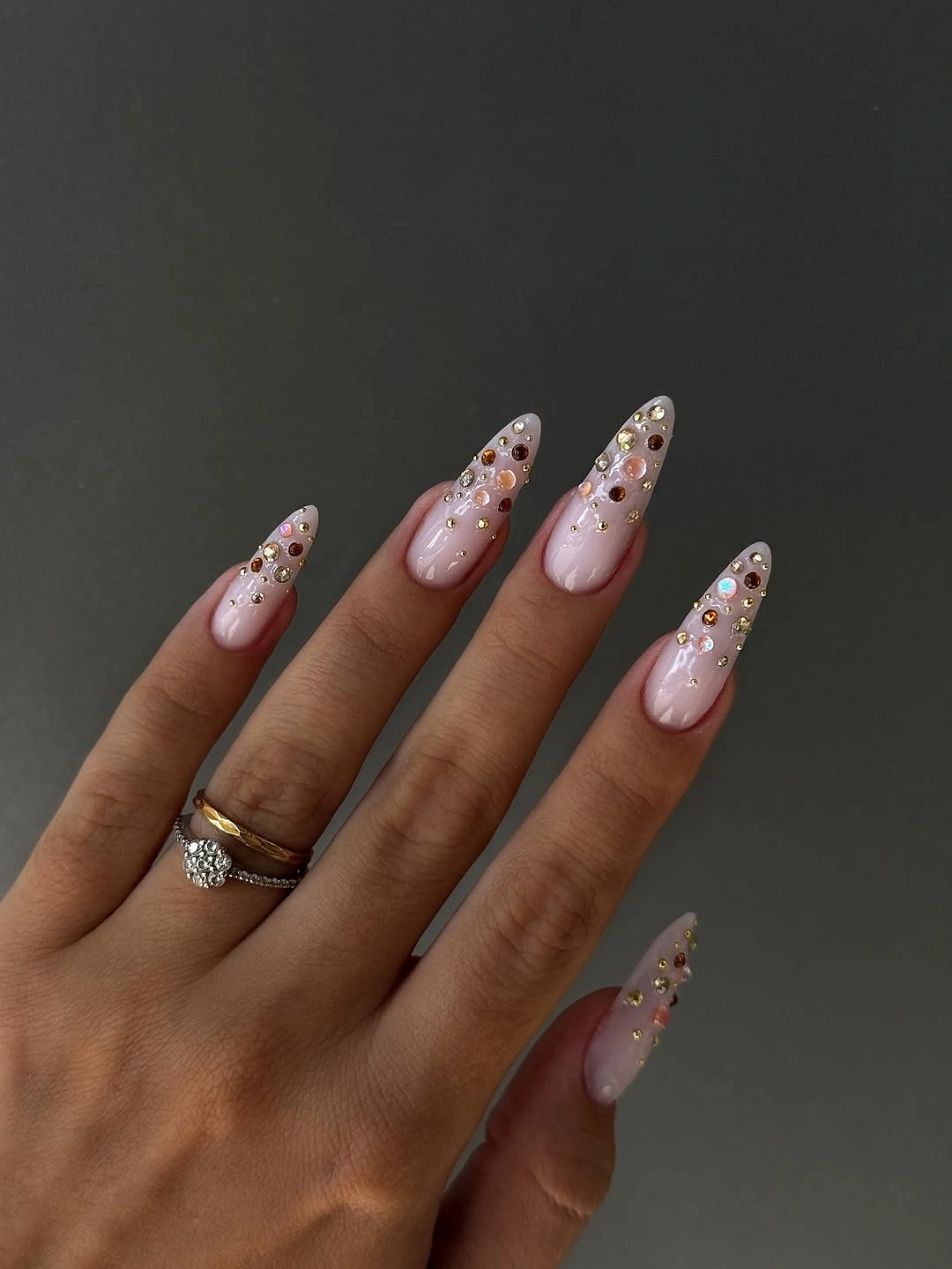 long pointed blush nails with glitter and small accents