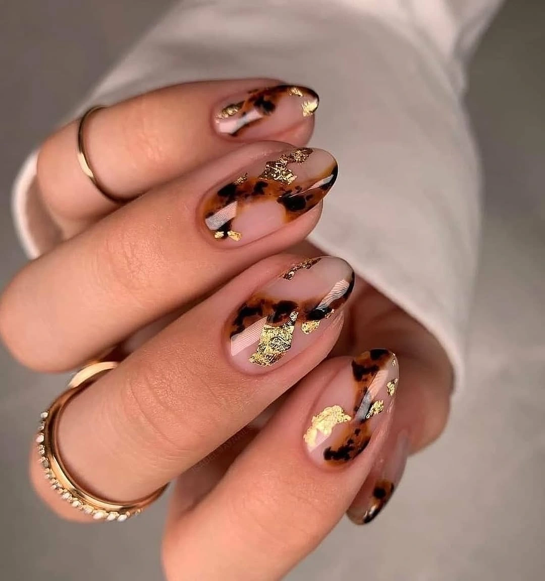 long almond nude nails with brown marbling and gold accents