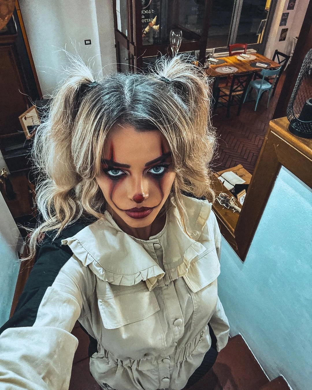 White ruffled clown blouse with small dark hat and face makeup