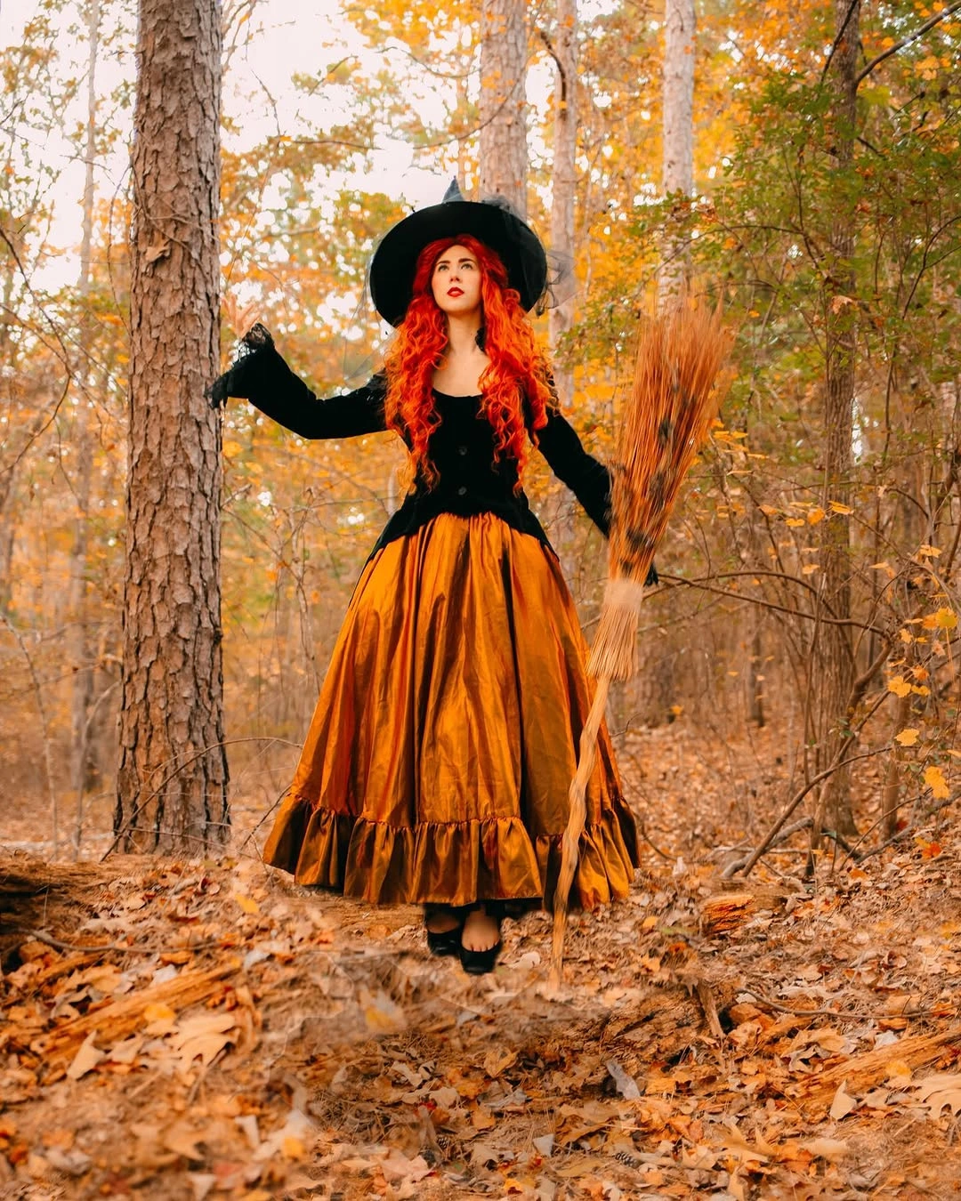 Black witch hat outfit with full orange skirt and broom