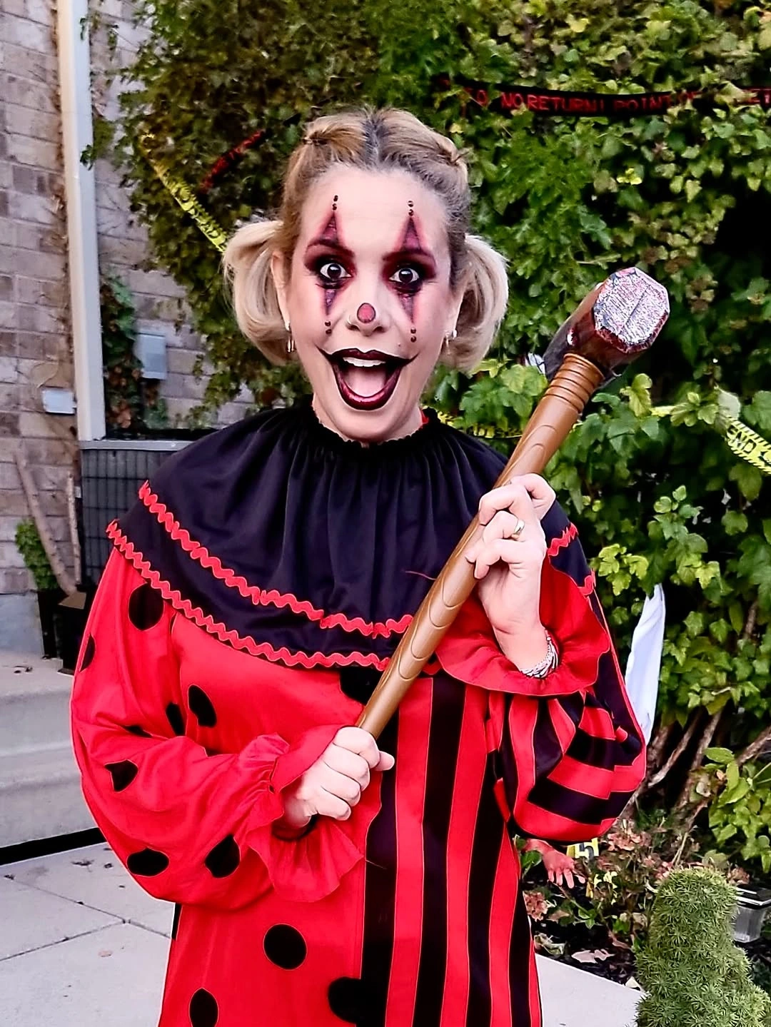 Red and black polka-dot clown costume with staff and ruffled collar
