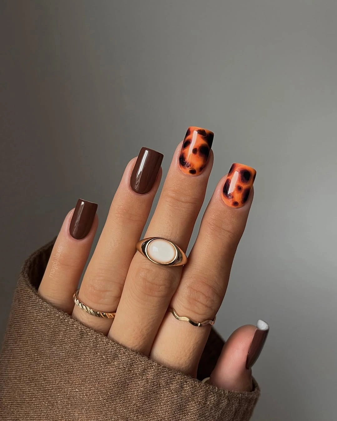 Short pink nails with brown polka dots and a light stripe