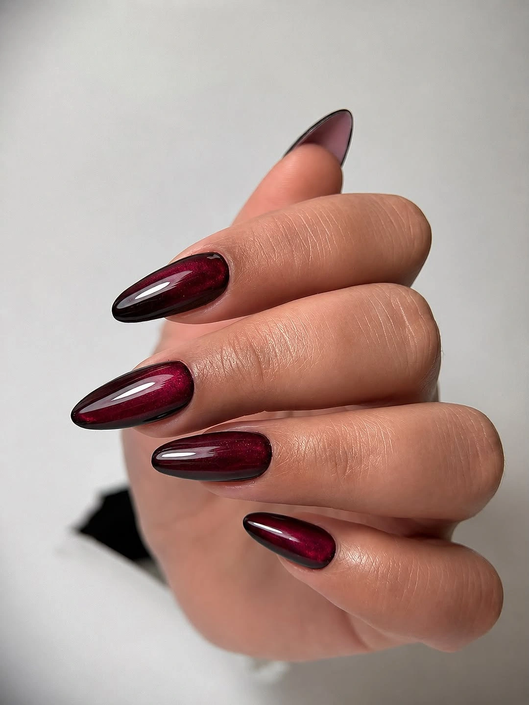 Rich glossy burgundy on long almond nails