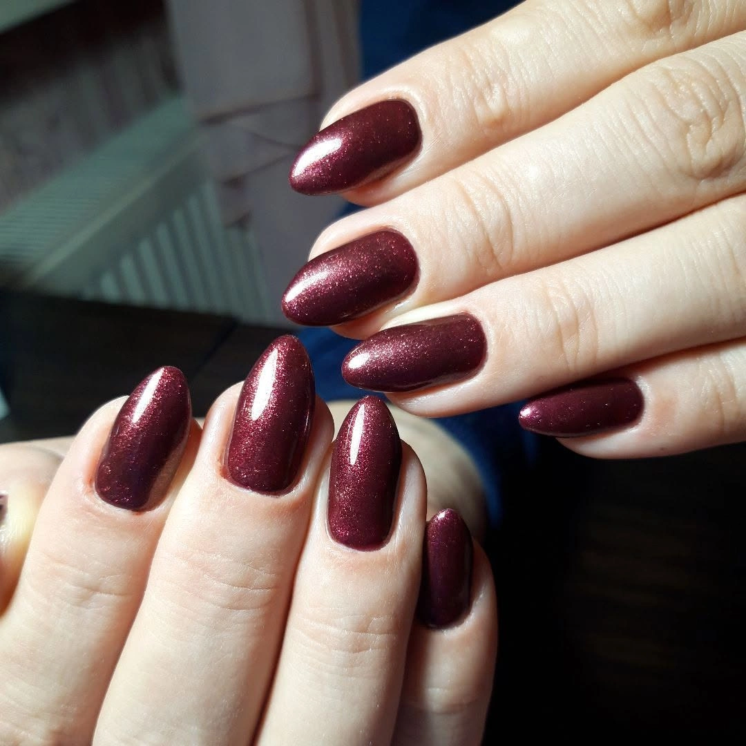 Dark wine rounded nails with a subtle metallic red shift