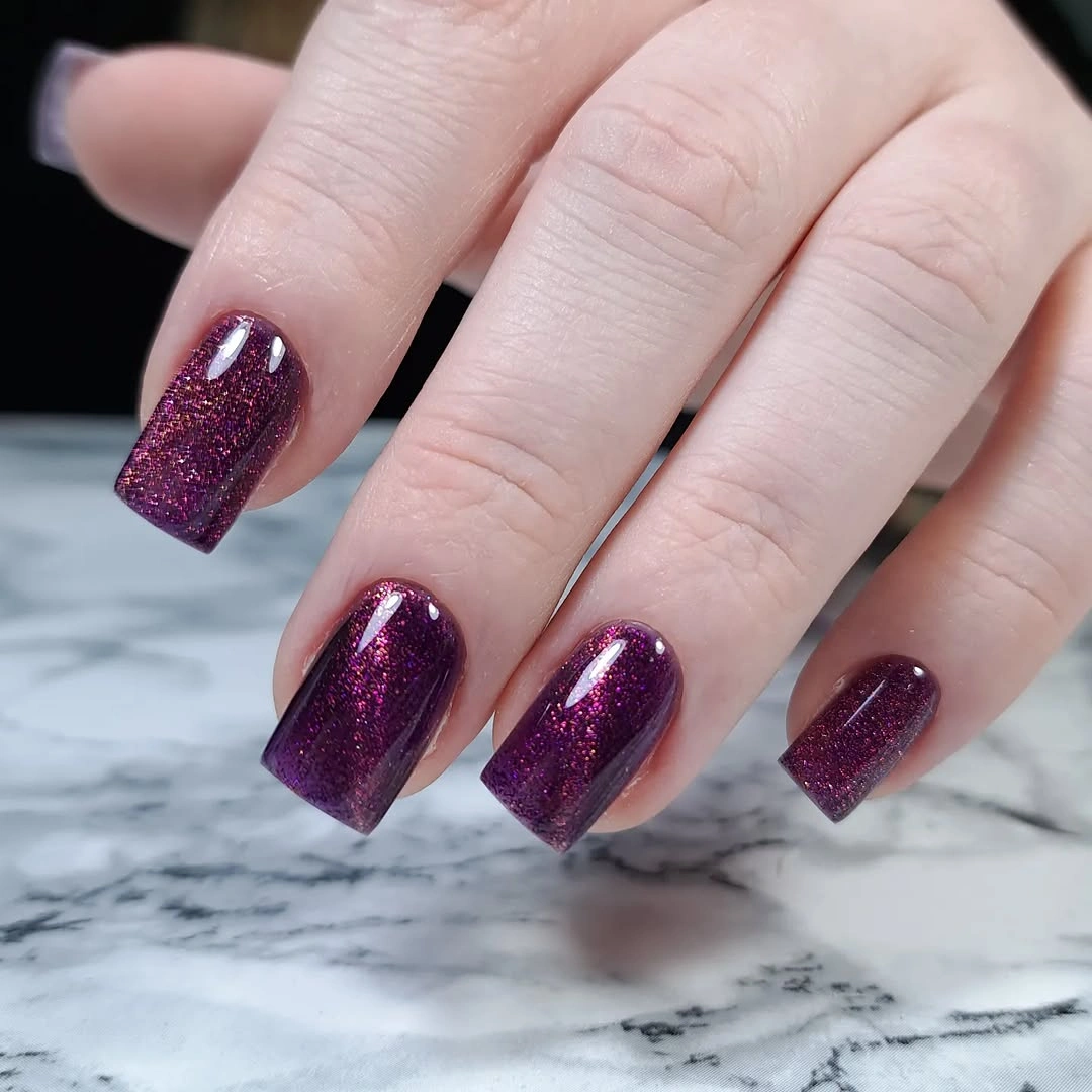 Purple burgundy rounded nails with fine reflective glitter