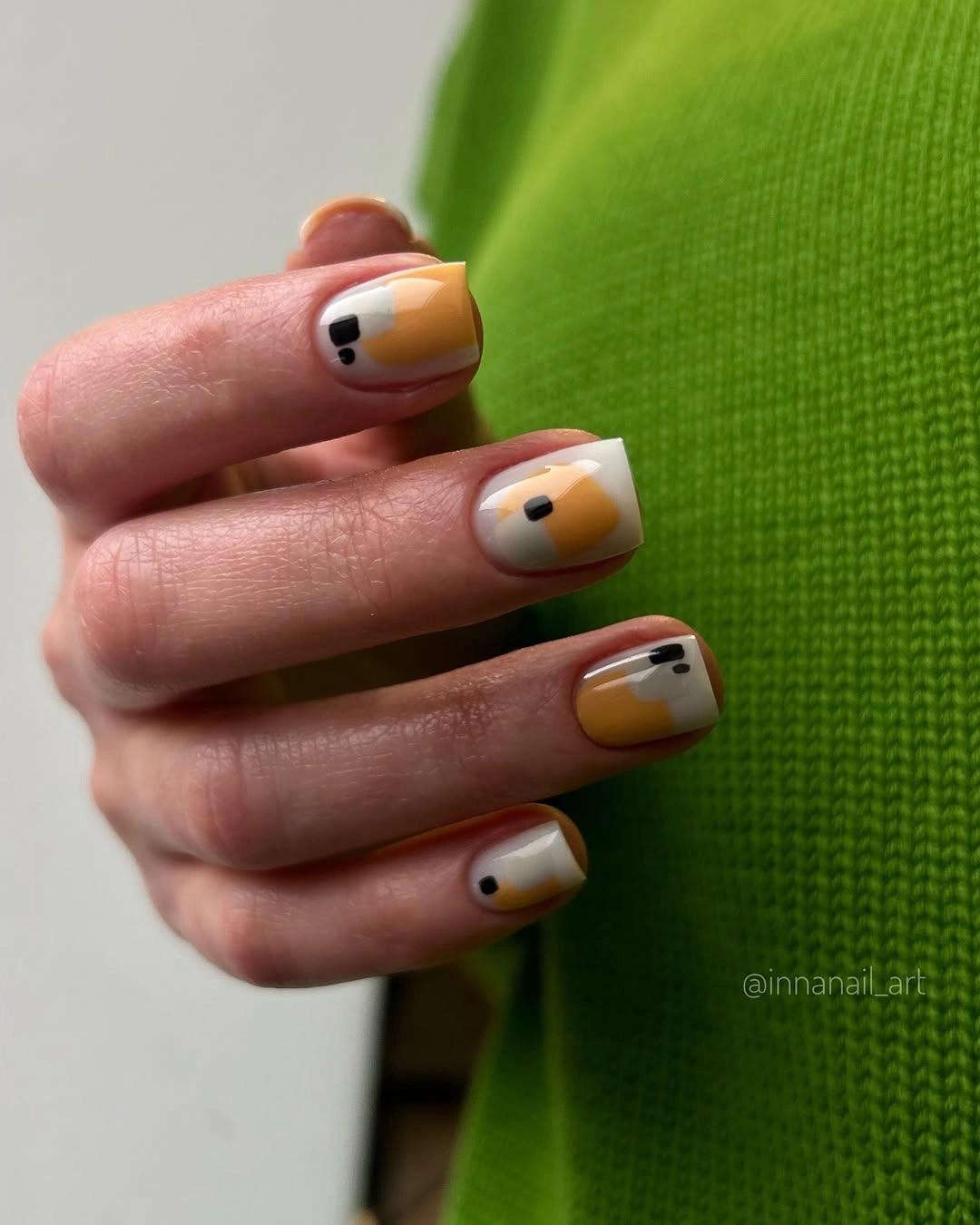 Cream square nails with tiny black yellow graphic marks