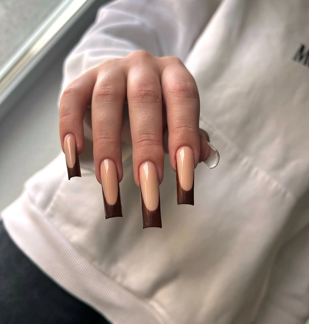 Sheer pink tapered nails with dark brown French tips