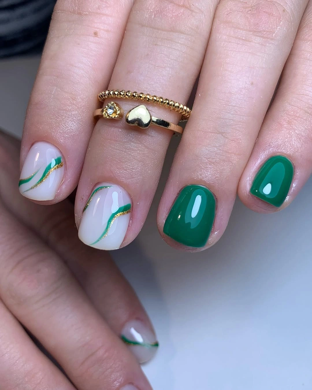 Dark teal square nails with pale curved botanical accents
