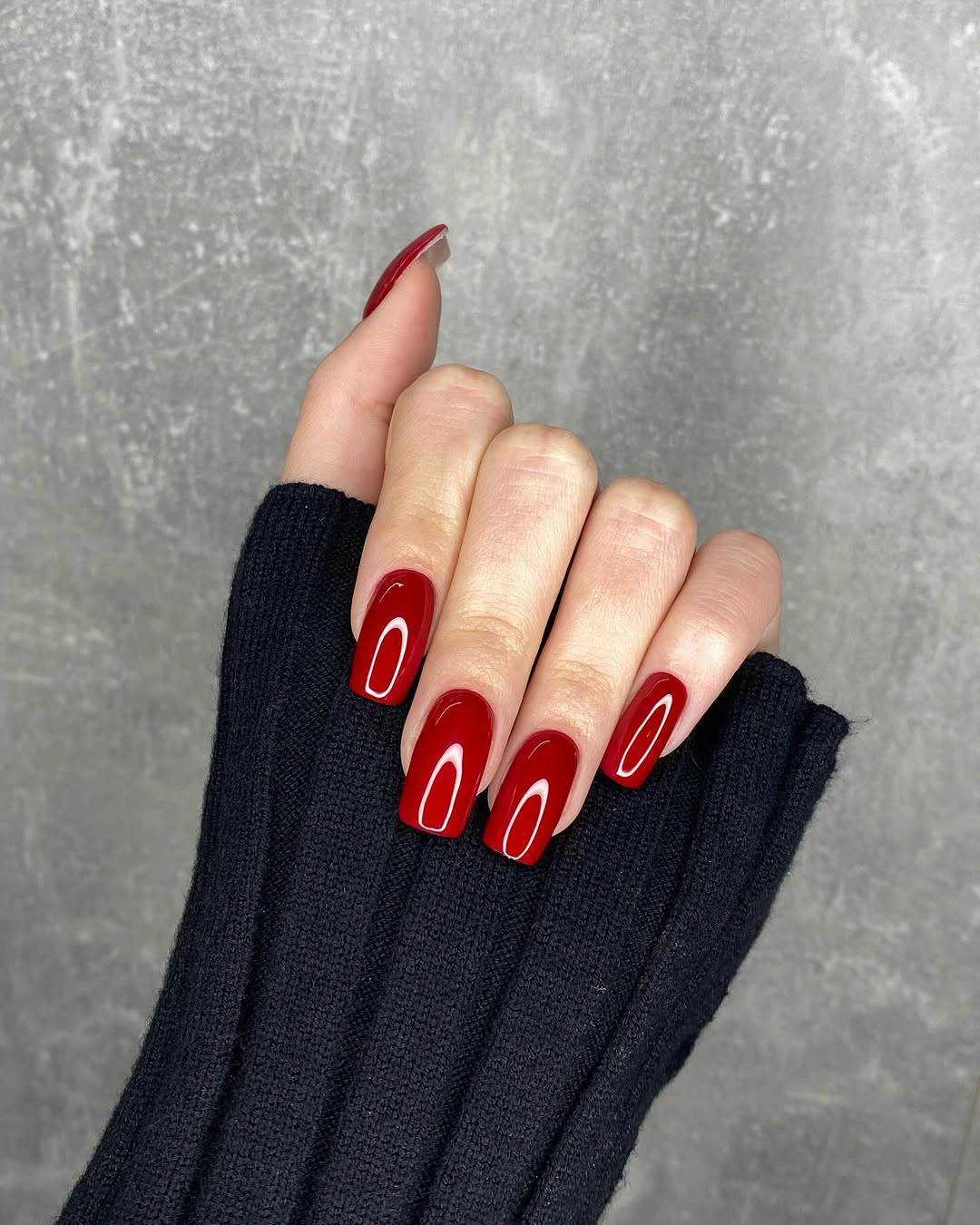 Deep red almond nails with slim white oval details