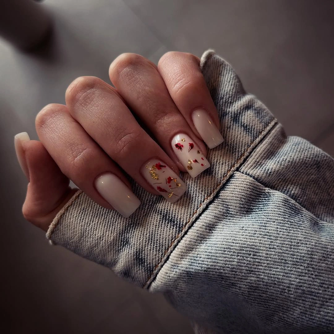 Sheer pink nails with small burgundy green floral accents