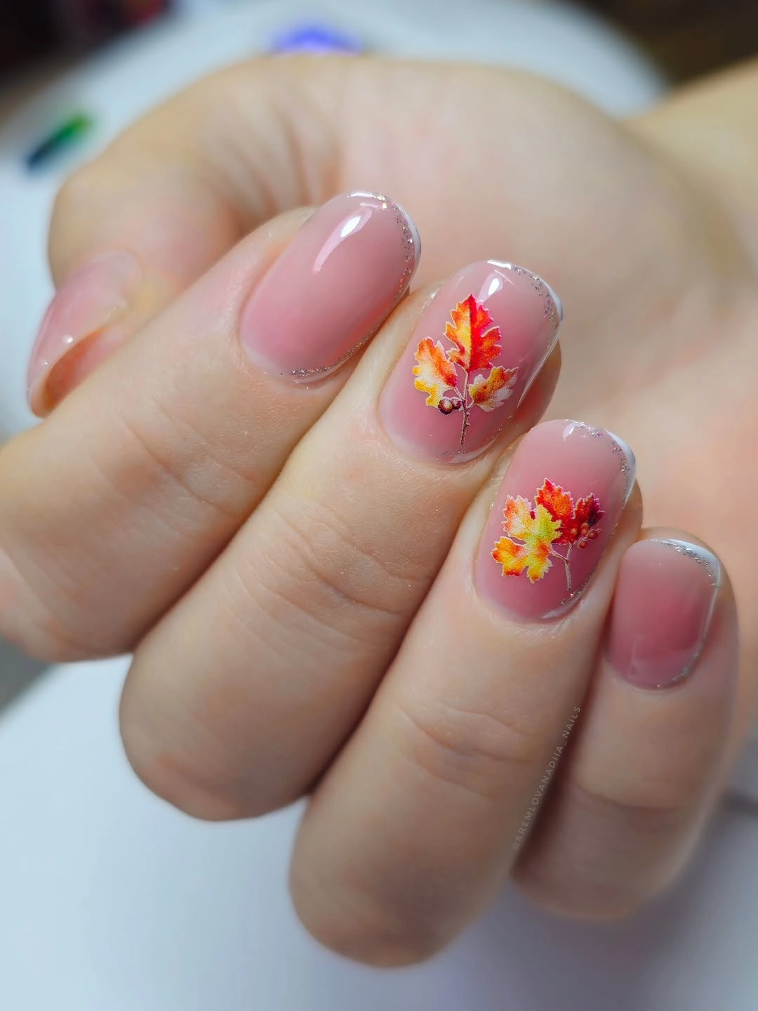 Sheer pink almond nails with silver tips and flowers