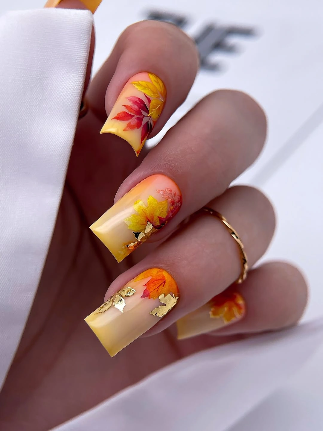 Orange yellow coffin nails with floral and foil accents