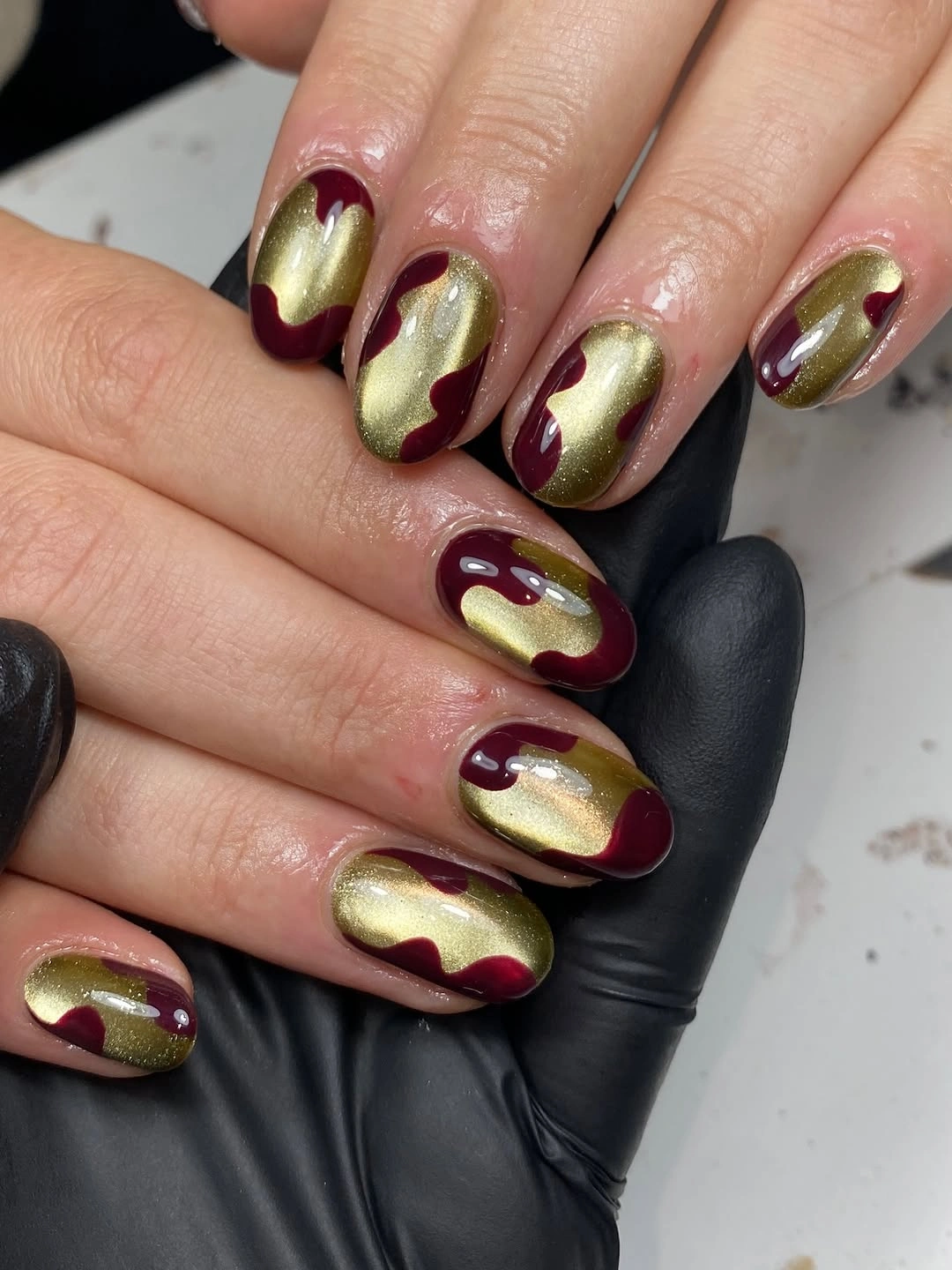 Short oval olive gold nails with burgundy scallops