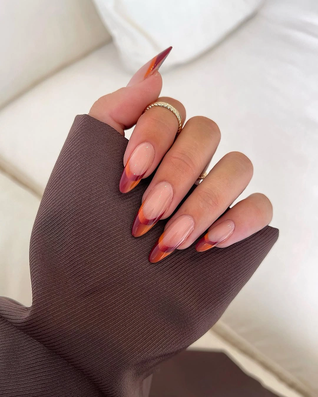 Long almond nude nails with orange burgundy tips
