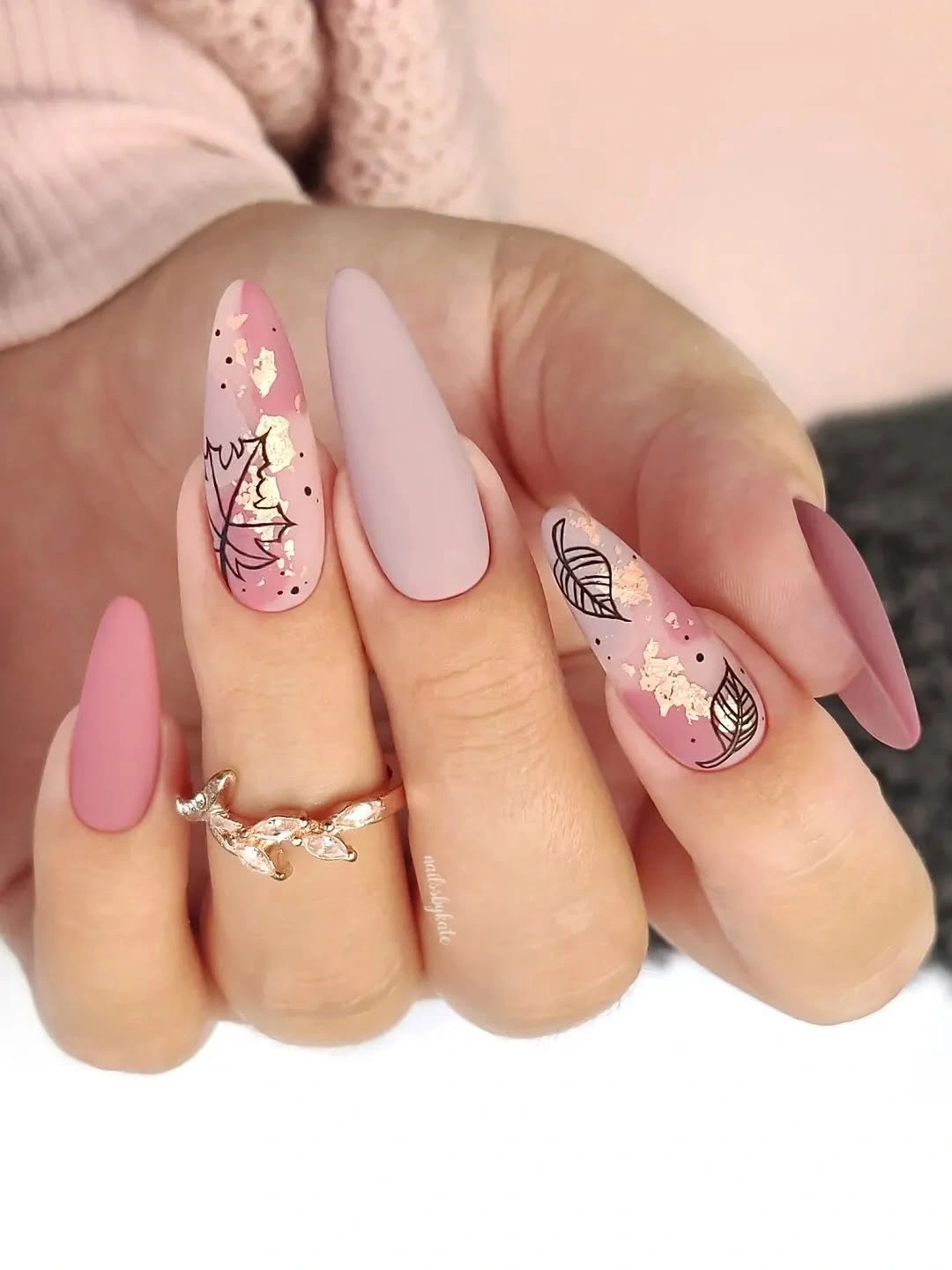 Matte pink almond nails with black botanical lines