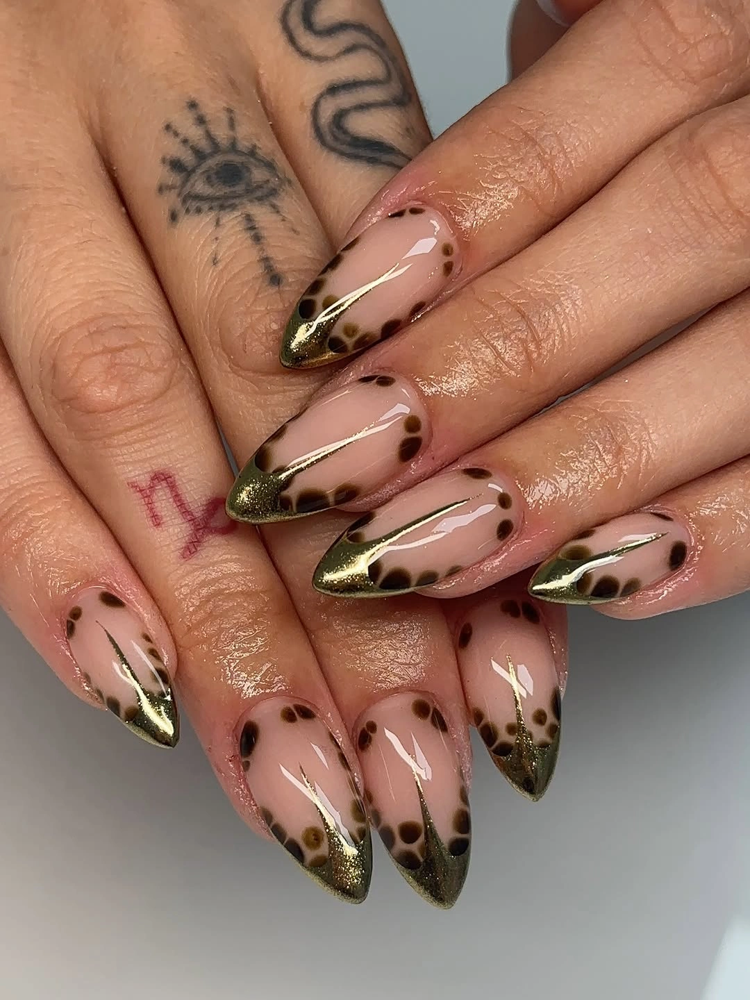 Long nude stiletto nails with olive gold tips