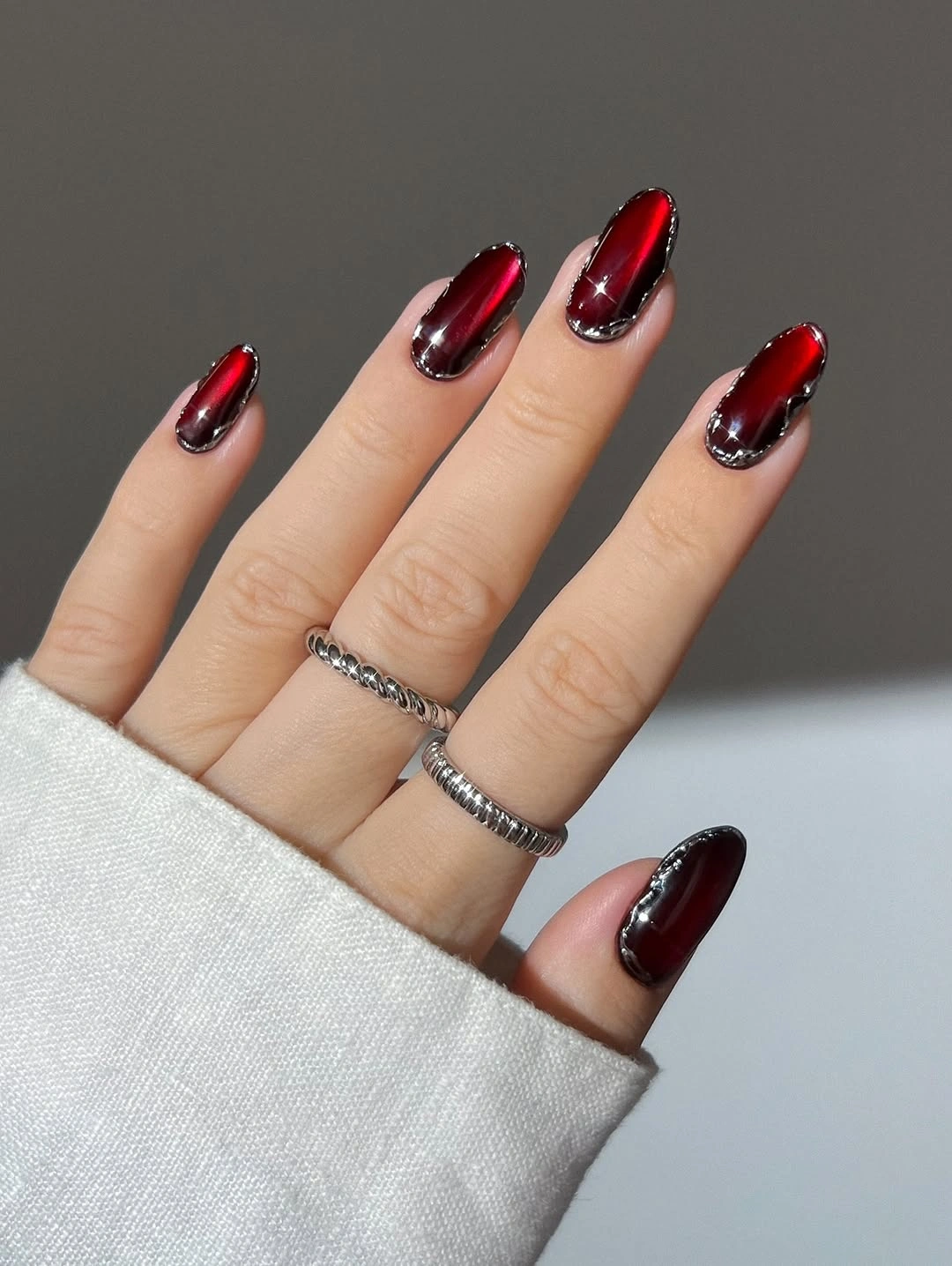 Short black cherry nails with silver edge detail