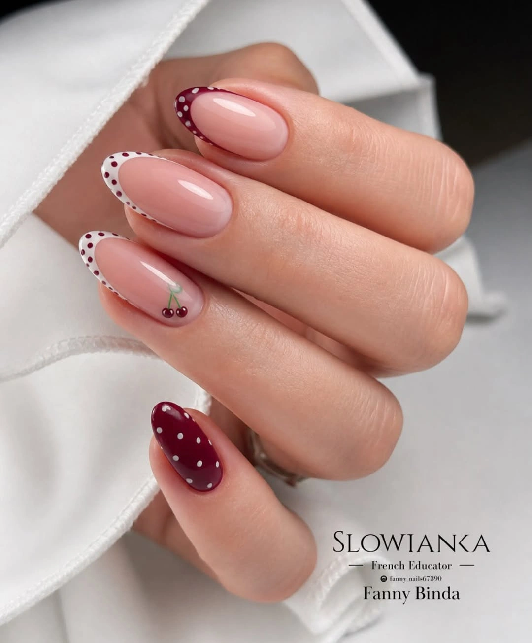 Burgundy dotted French almond nails with cherry accent