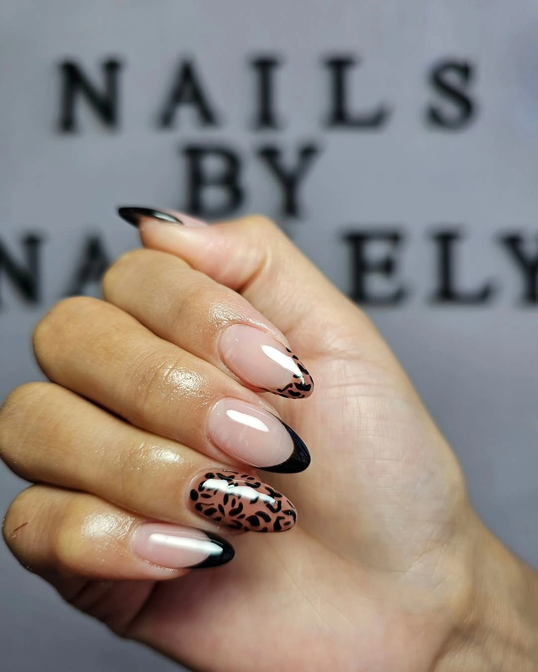 Nude almond nails with black tips and animal print