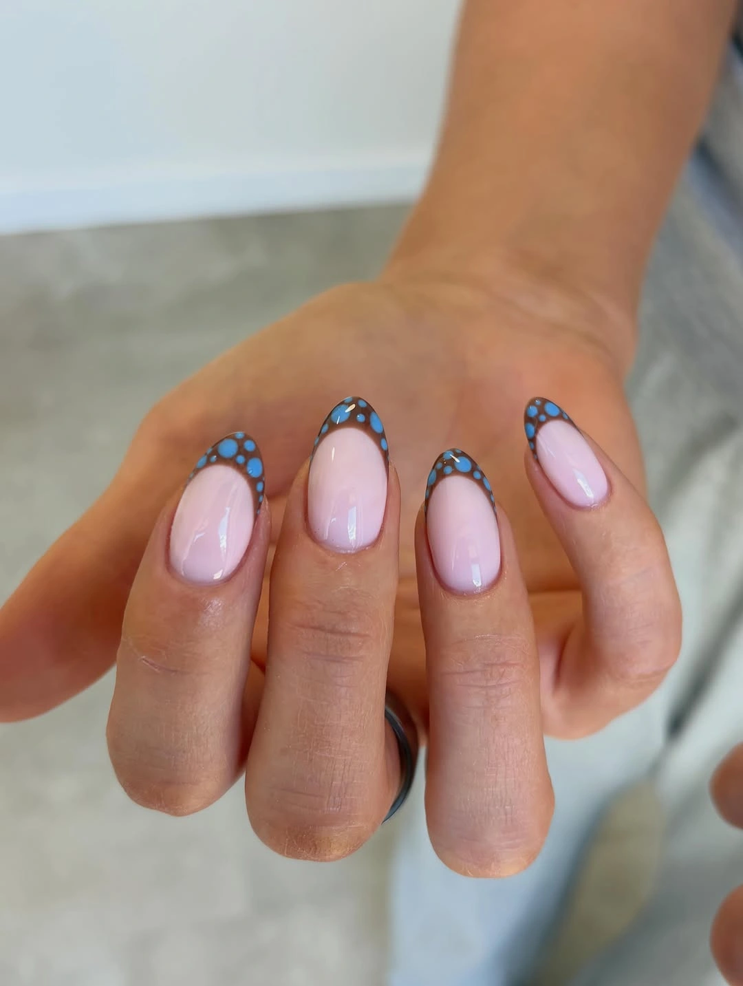 Short almond nails with brown tips and blue dots