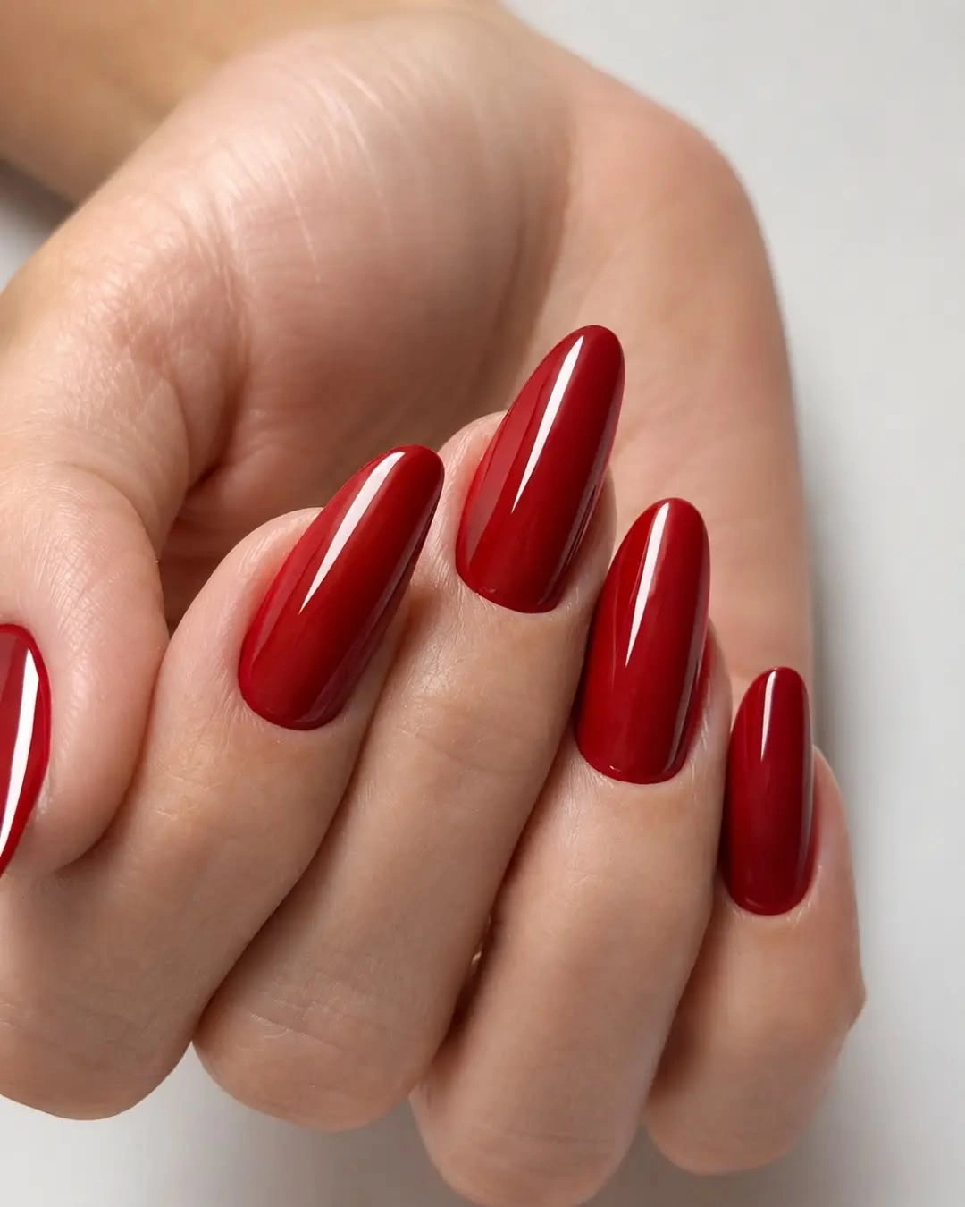 Long deep red almond nails with glossy finish