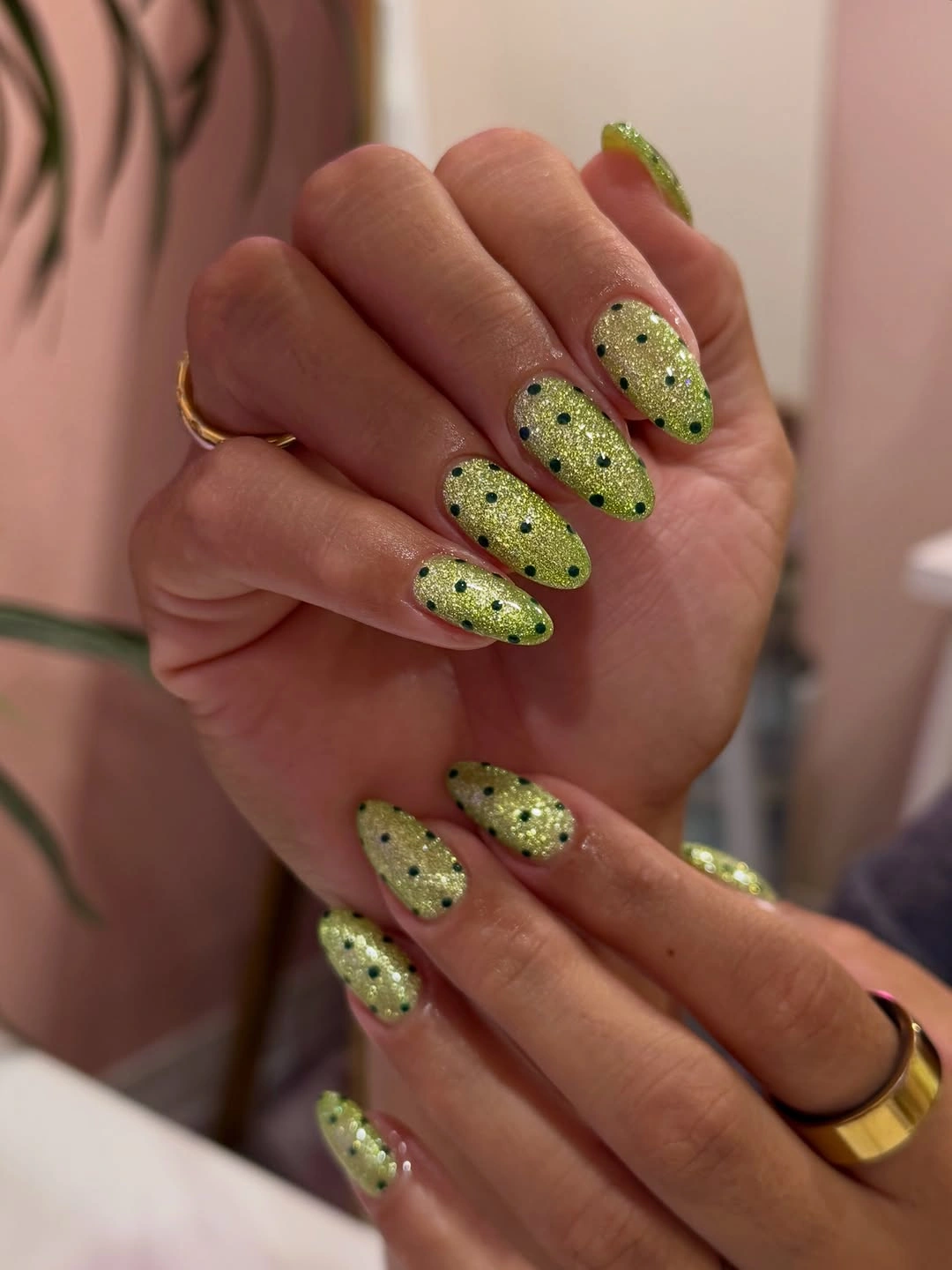Chartreuse glitter almond nails with dark dots