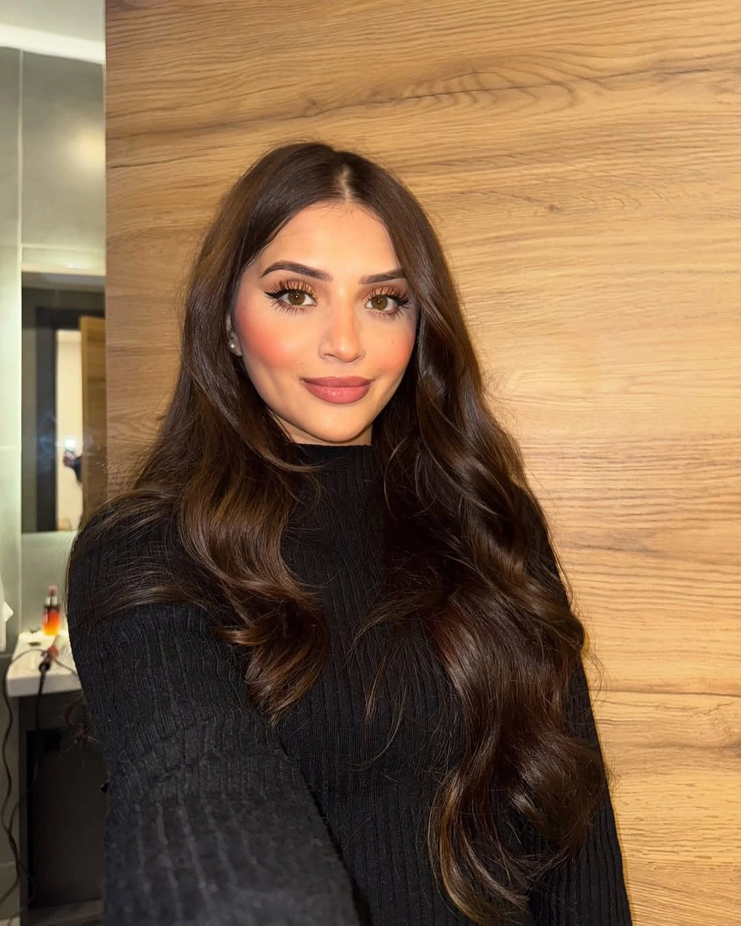 Long reddish brown hair with a full fringe and loose waves