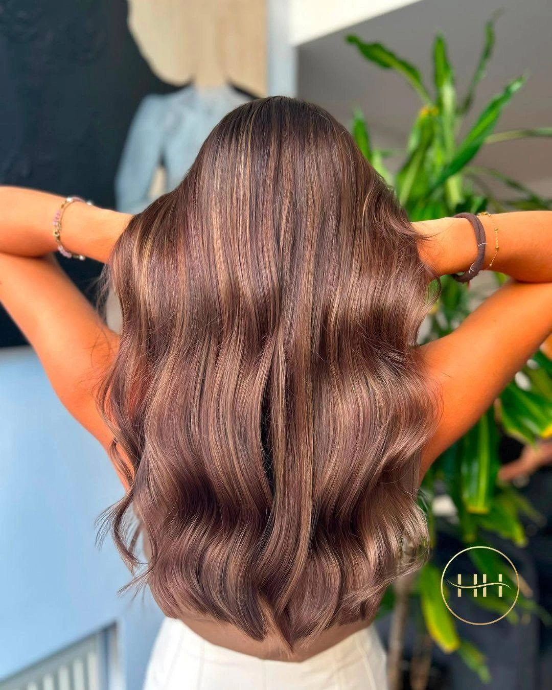 Long warm brown hair with broad waves and a rounded lower shape