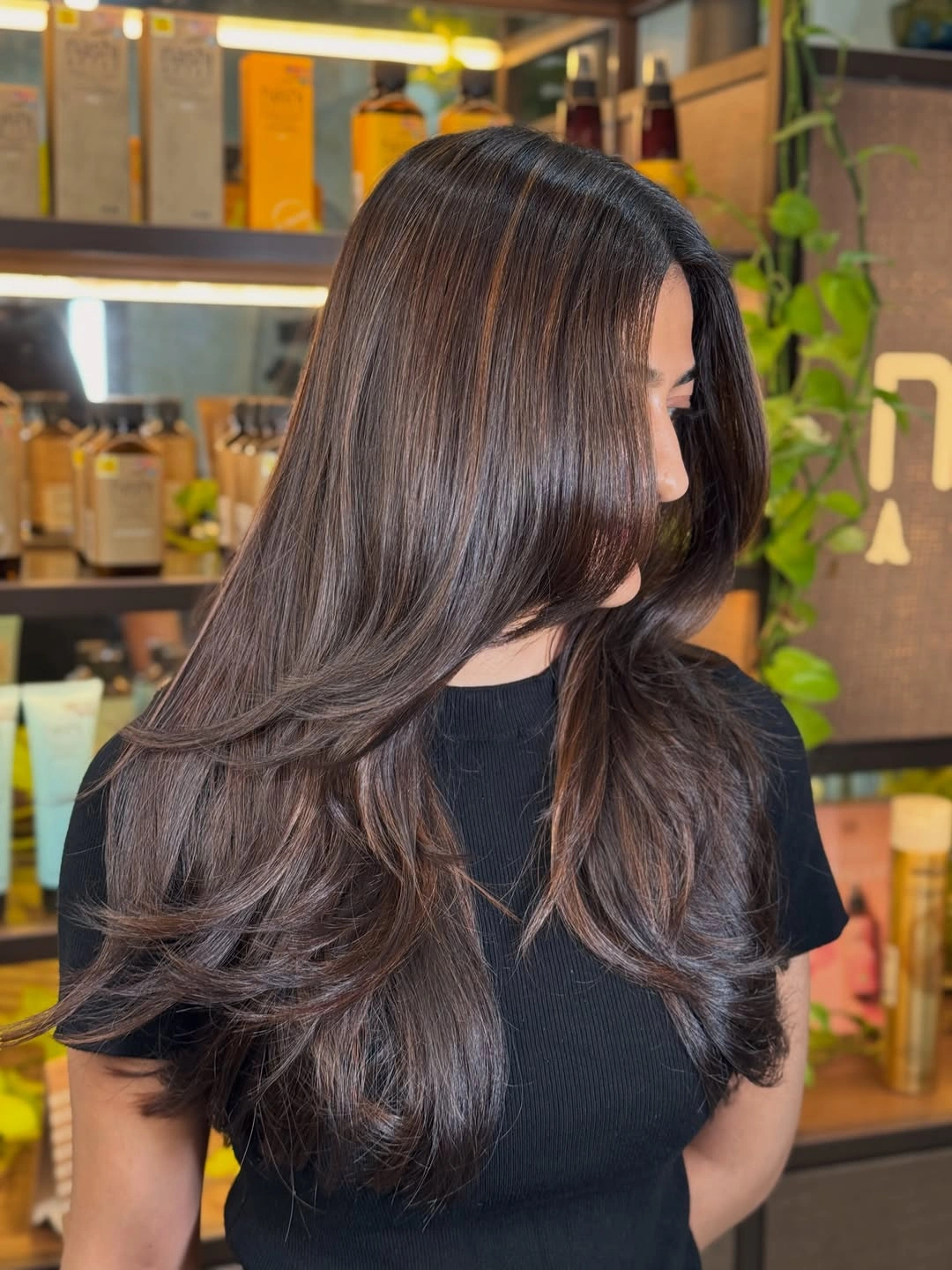 Long deep brown hair with face-framing layers and soft flipped ends