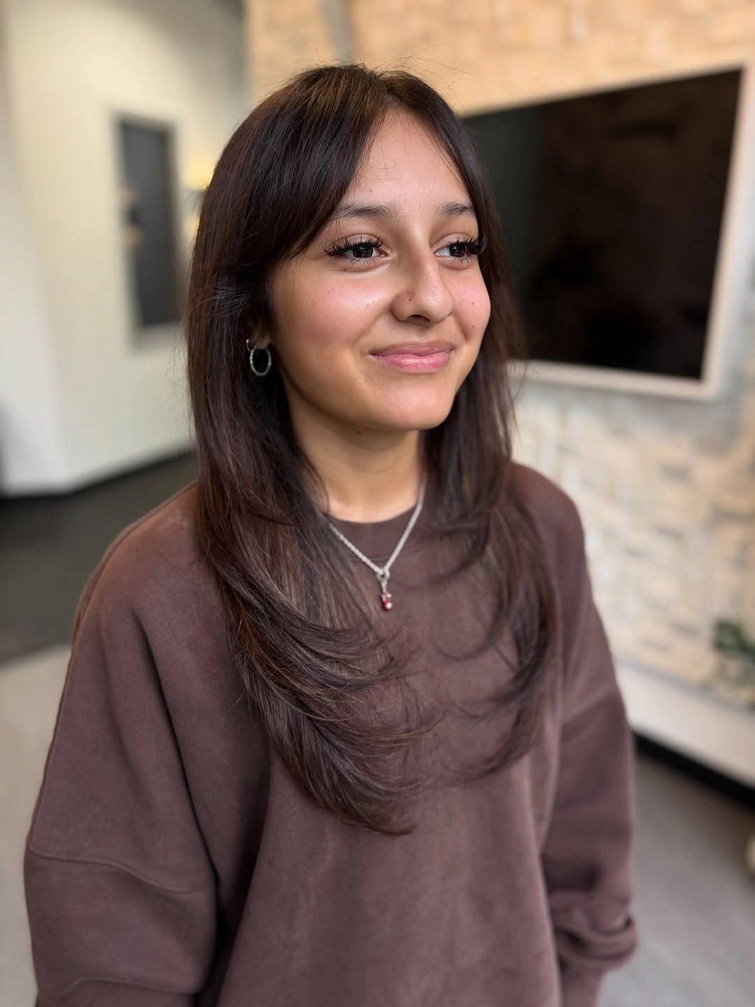 Medium-long brown hair with smooth face framing and a gentle bend