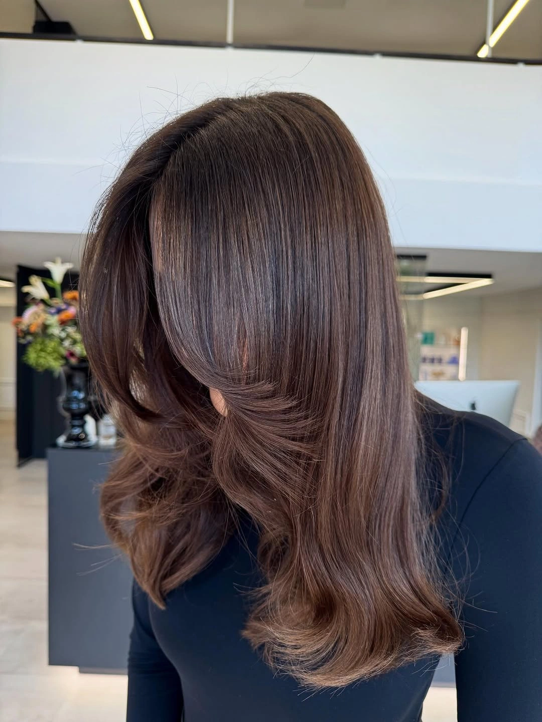 Medium-long medium brown hair with rounded layers and curled ends