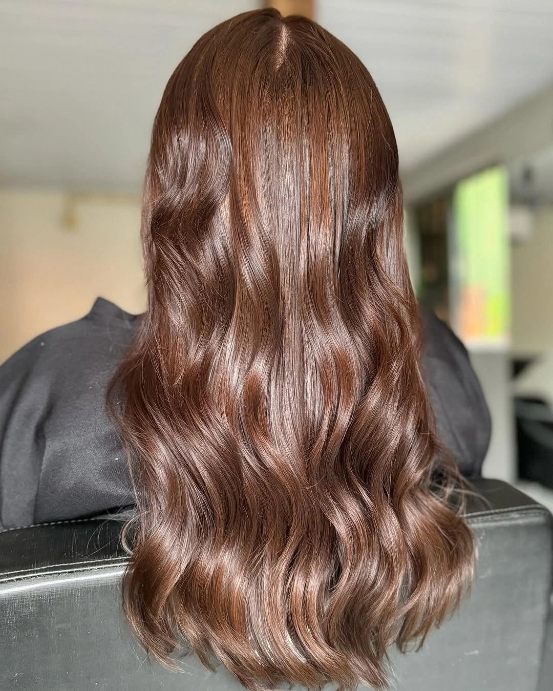 Long warm copper brown hair in glossy loose S-shaped waves