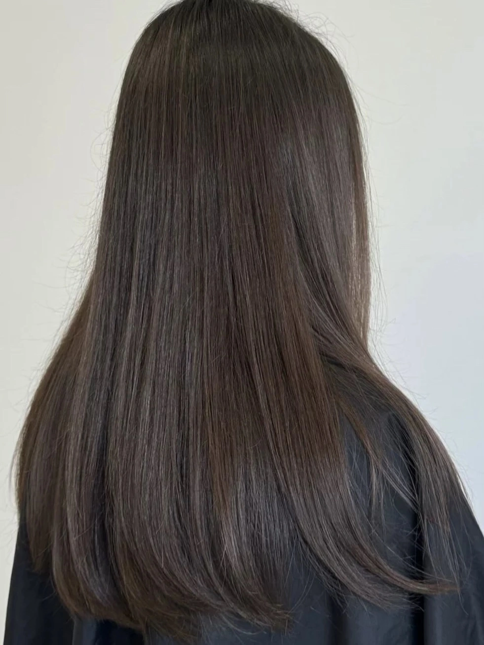 Long cool dark brown hair with a smooth straight finish