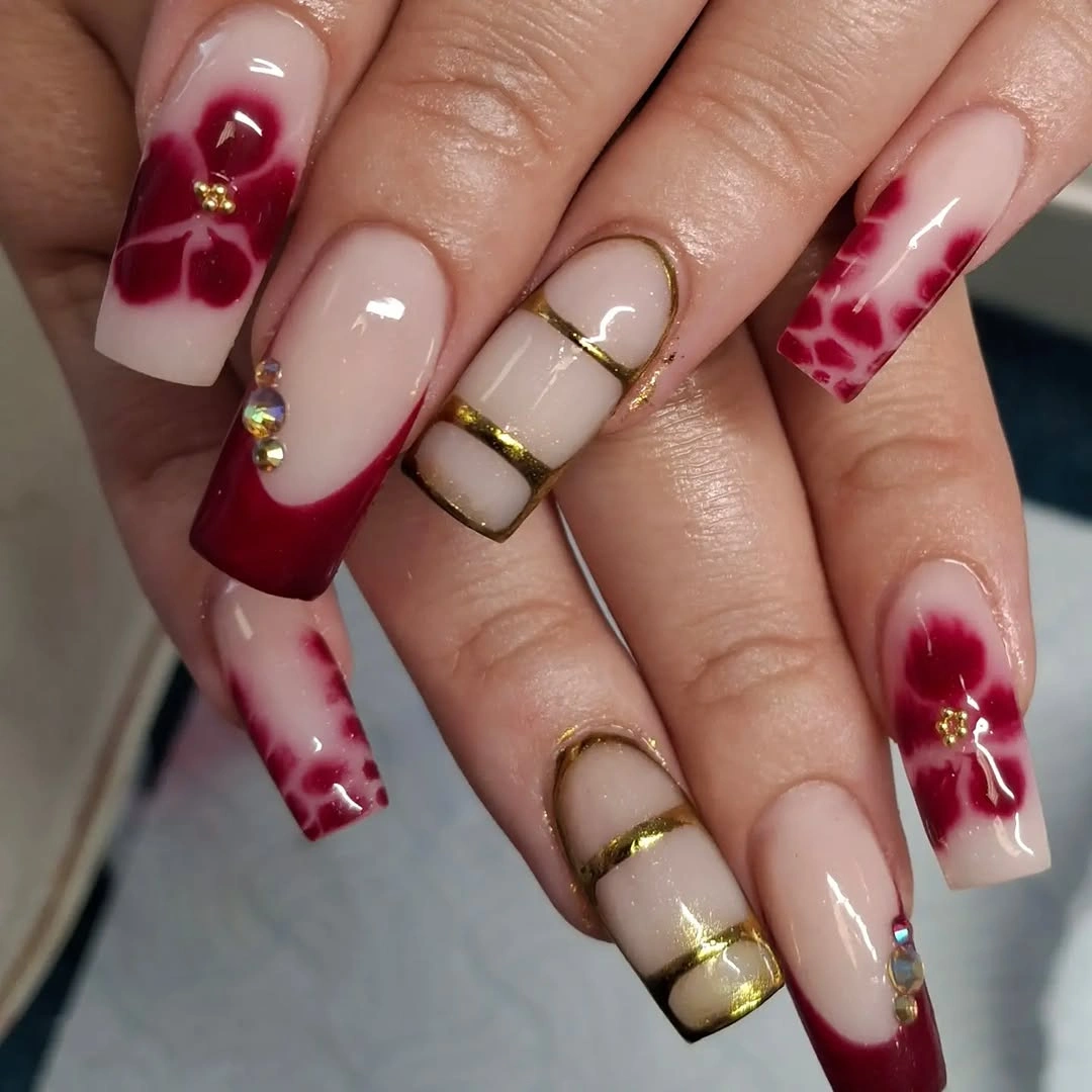long coffin nails with burgundy French tips and pale ornate accents